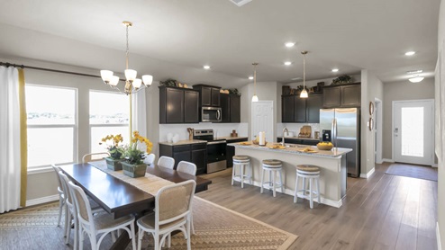 Warrior's Legacy model home dining room with view of kitchen and the front door.