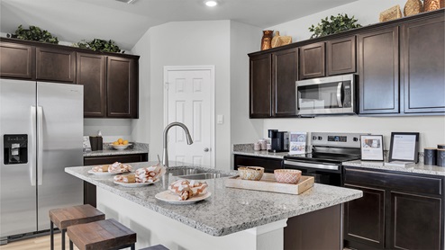 Lake Pointe Terrace kitchen with dark cabinets and granite countertops.