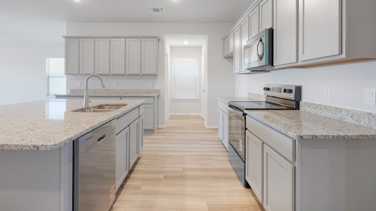 Creekside Hills model home kitchen with light cabinets and granite countertops.