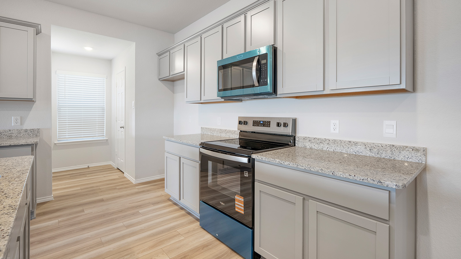 Creekside Hills model home kitchen with light cabinets and granite countertops.