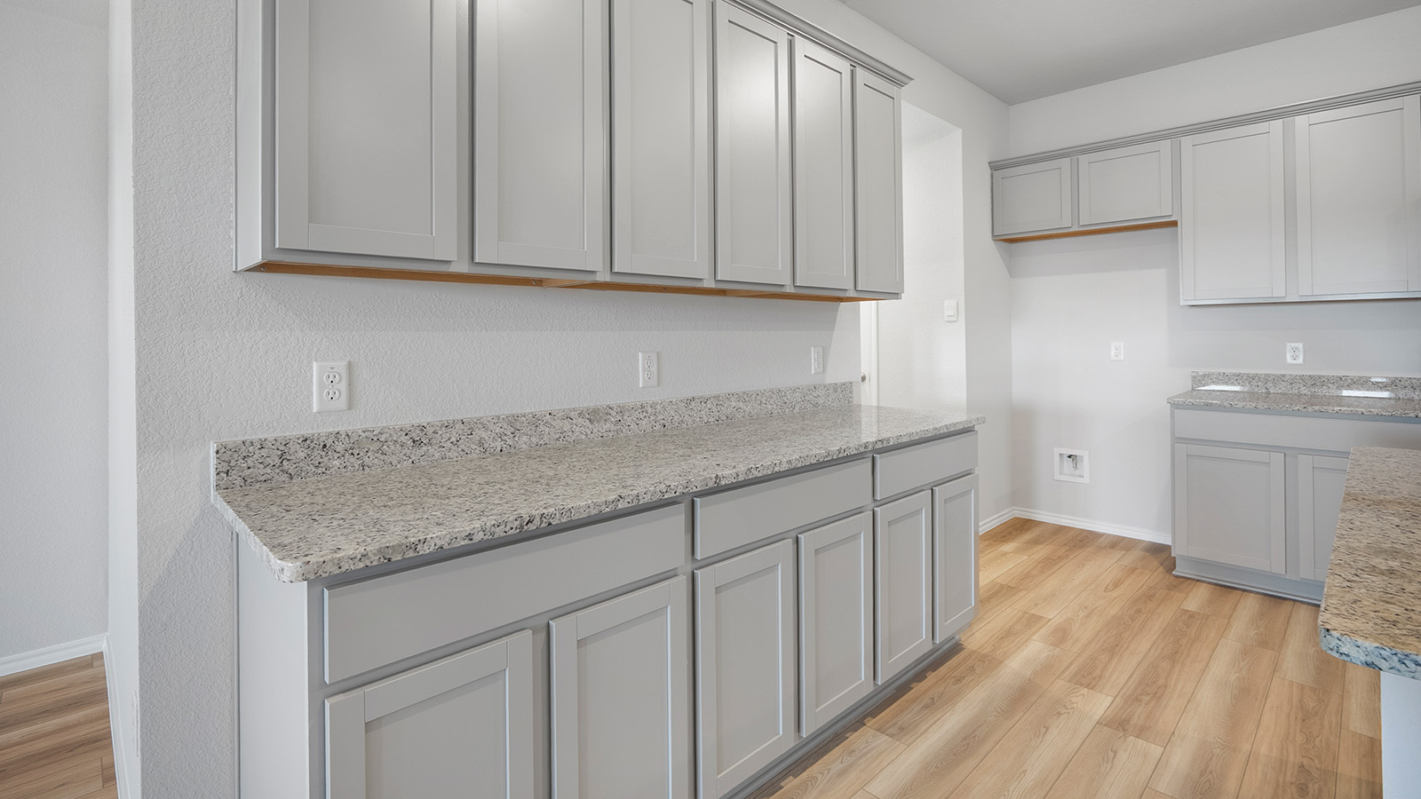 Creekside Hills model home kitchen with light cabinets and granite countertops.