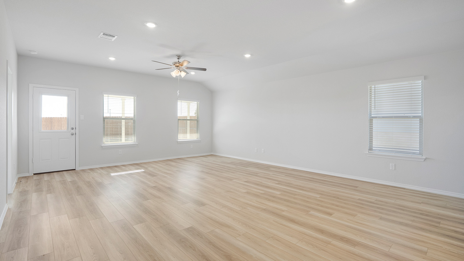 Creekside Hills model home living room with windows for natural lighting and view of back door.