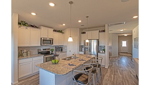 Creekside Hills model home kitchen with white cabinets and granite countertops.