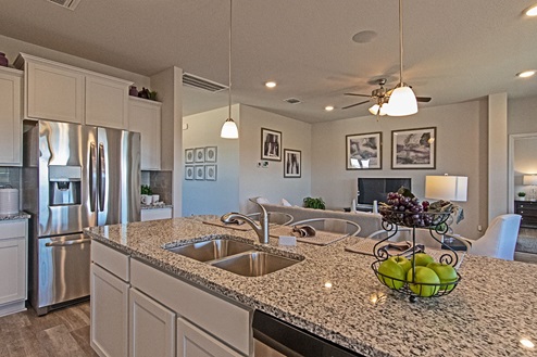 Creekside Hills model home kitchen with white cabinets and decorative accents.