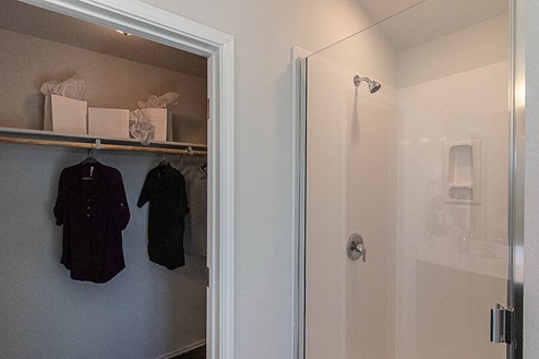 Creekside Hills model home primary bathroom with dark cabinets and white countertops.