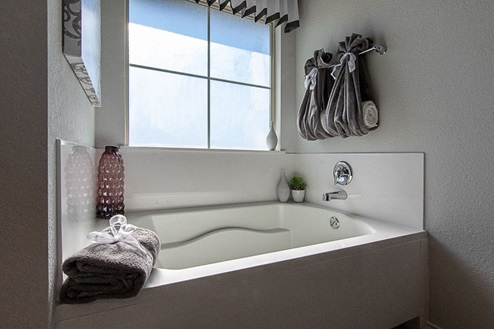 Creekside Hills model home primary bathroom with garden tub and window.