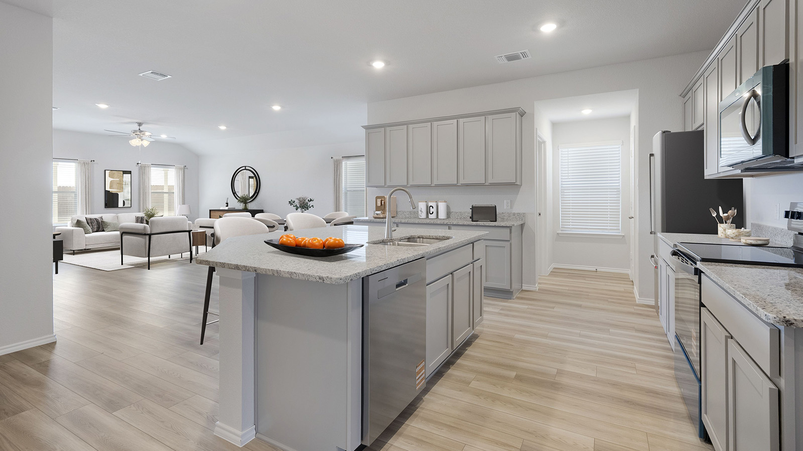 Creekside Hills model home kitchen with kitchen island with light cabinets and granite countertops.
