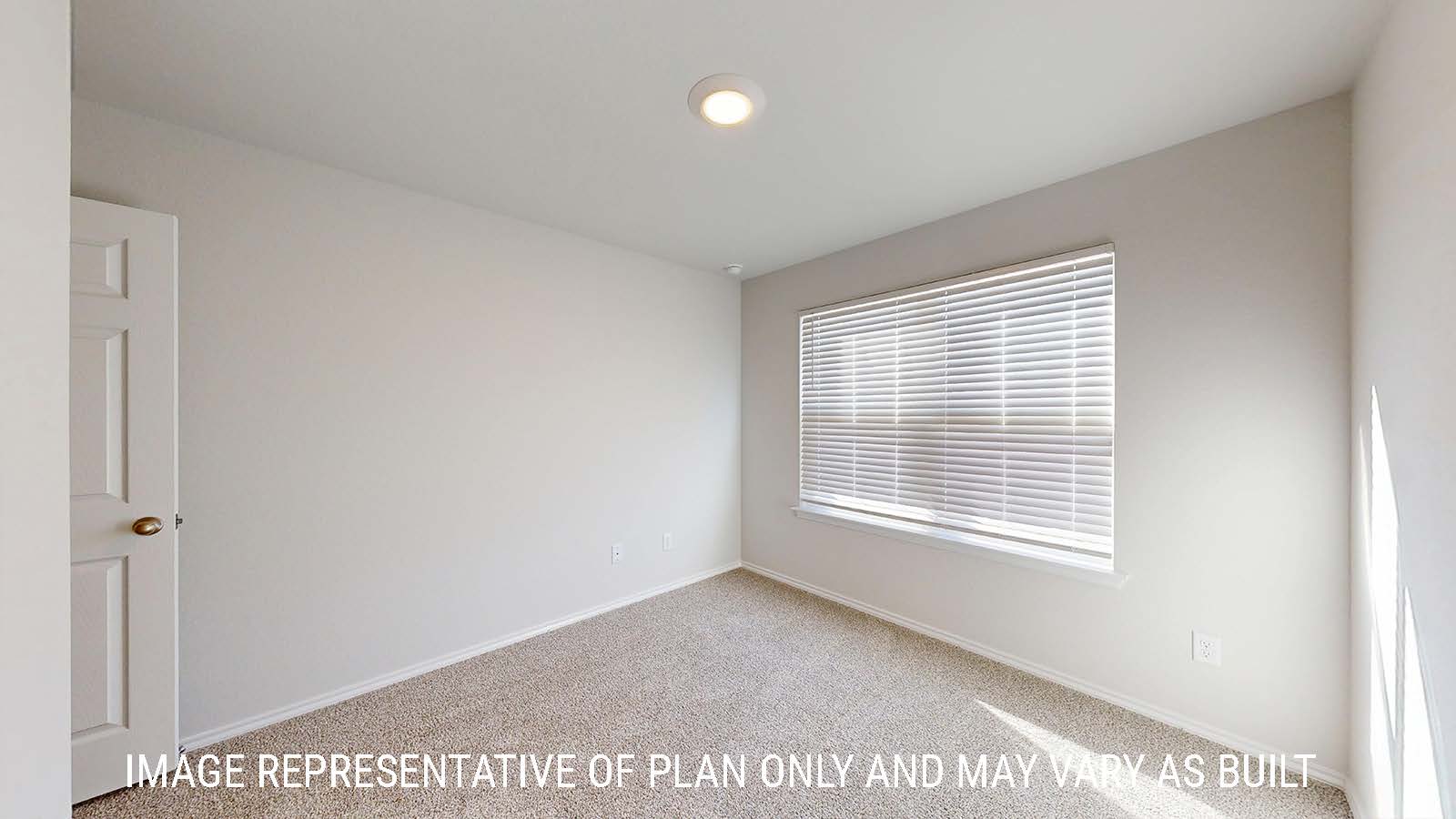 Caden secondary bedroom with carpeted flooring and window for natural lighting.