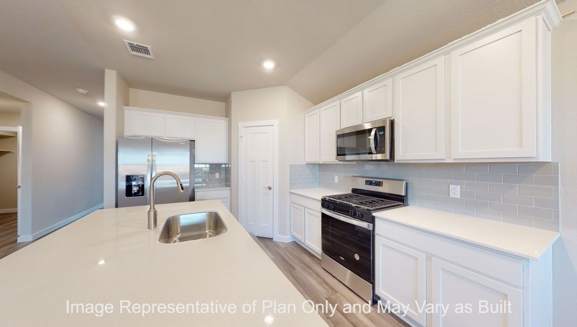 Harris kitchen with large kitchen island, quartz countertops and white cabinets.
