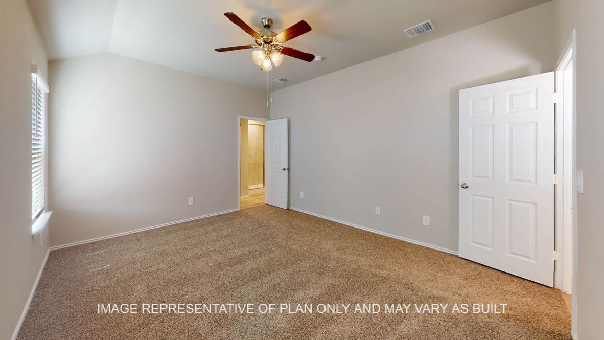 Camden primary bedroom with carpet flooring and door into primary bath.