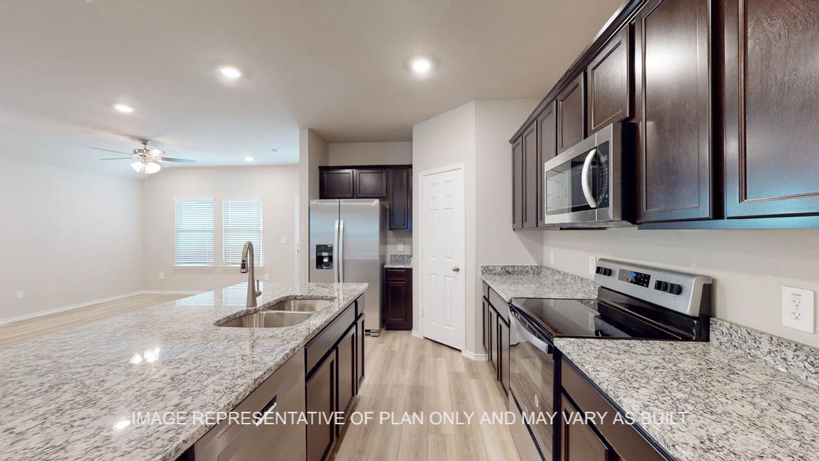 Camden kitchen with vinyl plank flooring, dark cabinets and granite countertops.