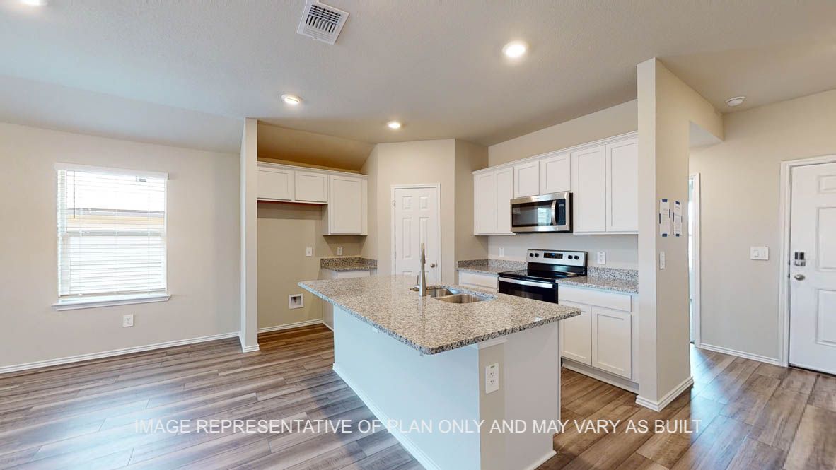 Elgin kitchen with vinyl plank flooring, white cabinets and granite countertops.