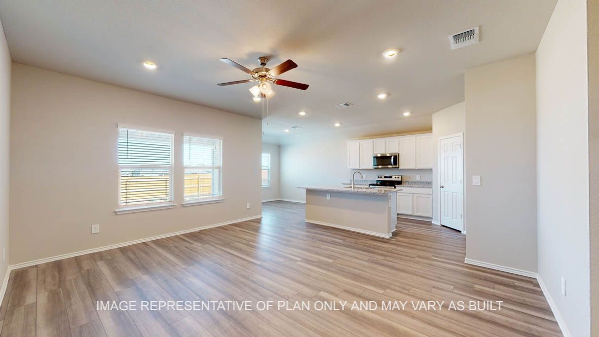 Fargo living room with vinyl plank flooring that flows into the kitchen and dining room.