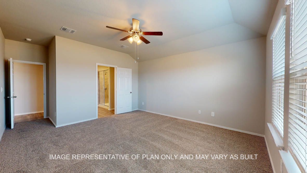 Fargo primary bedroom with carpet flooring and windows.