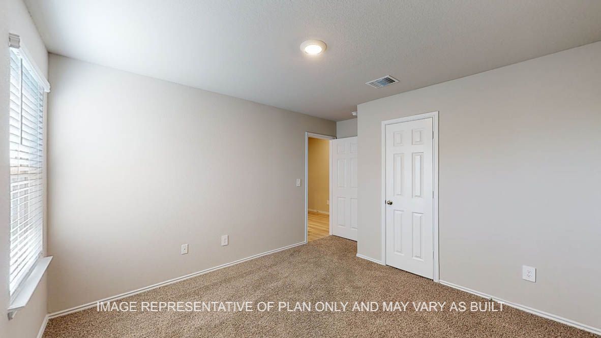 Texas Cali secondary bedroom with carpet flooring and closet door.