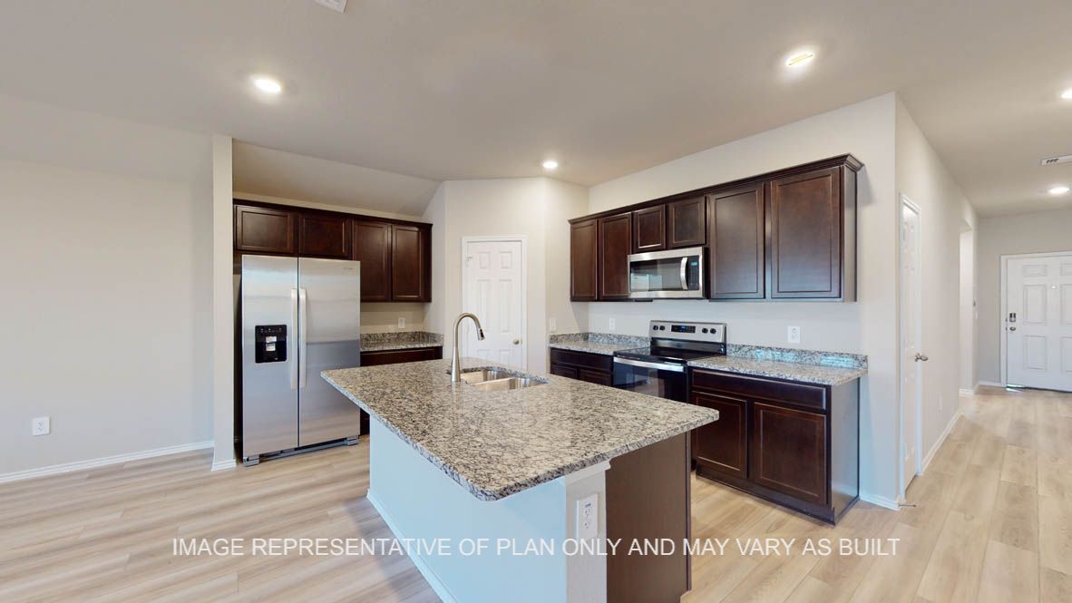 Texas Cali kitchen with large island and granite countertop with dark cabinets.
