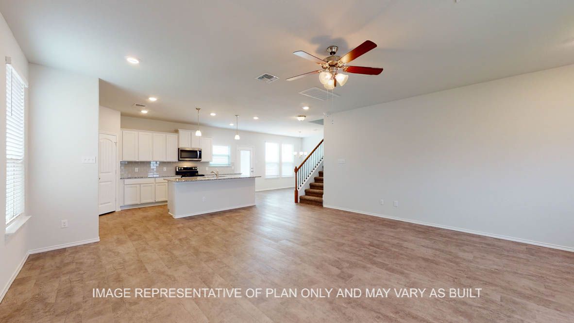 Aspen living room with vinyl plank flooring throughout and access to stairs.