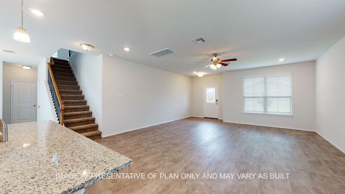 Aspen living room with vinyl plank flooring throughout and access to stairs.