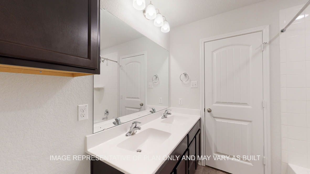 Aspen primary bath with white countertops and dark cabinets.