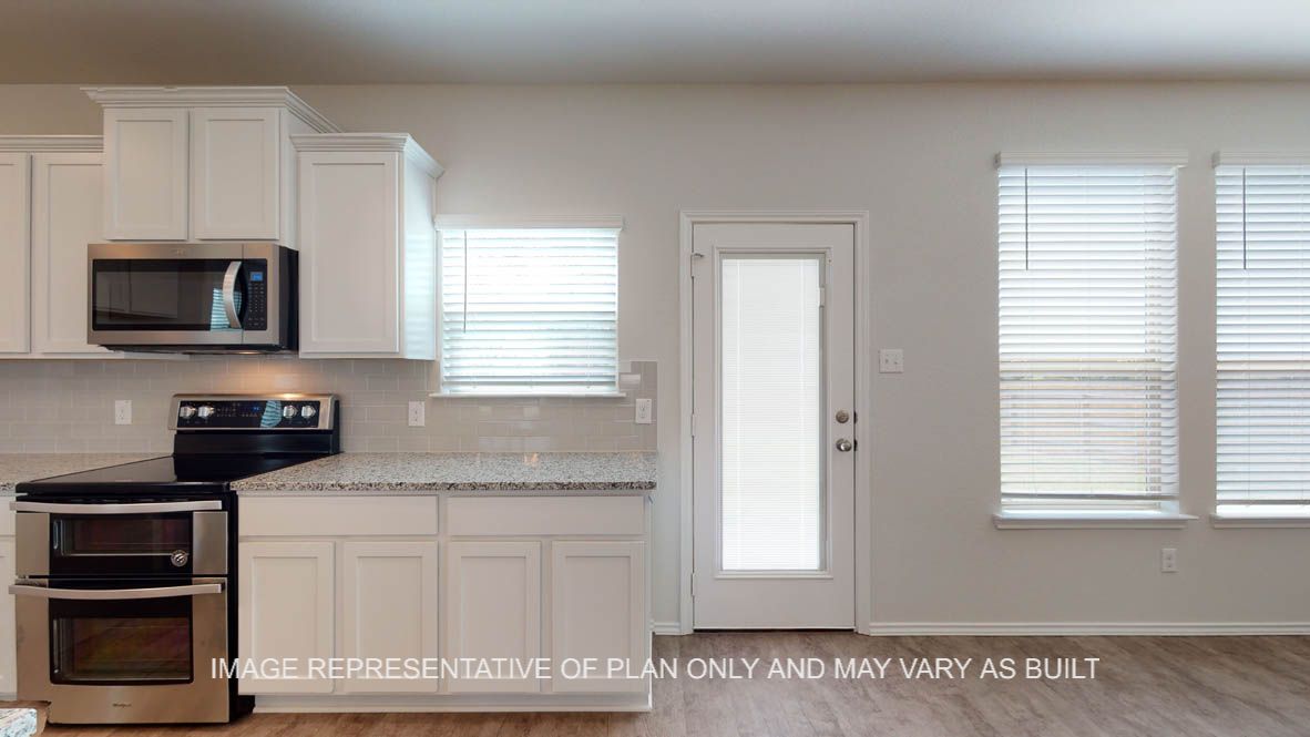 Aspen kitchen with stainless appliances and view to patio door.