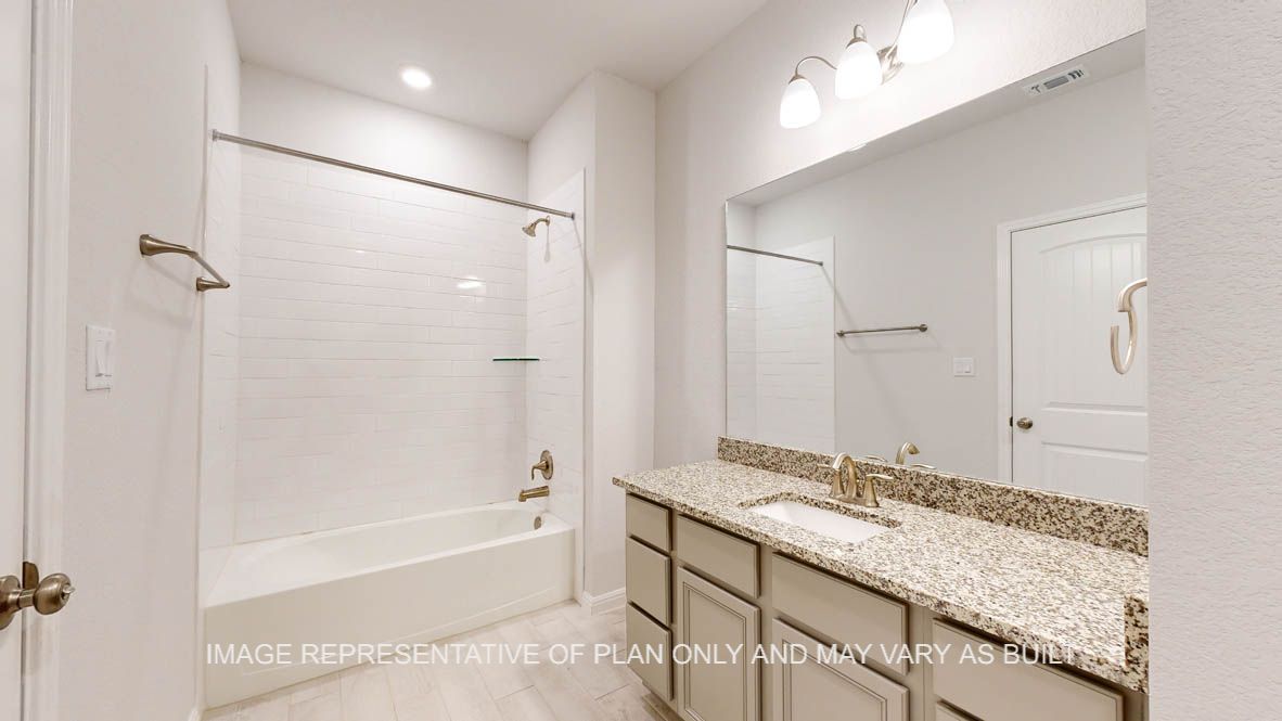 Parker secondary bath with granite countertops and wood look tile flooring.