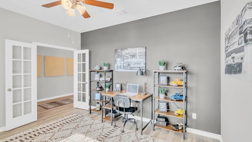 Village at Nolan Heights model home secondary bedroom with view of a desk and chair.
