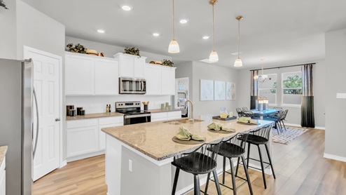 Village at Nolan Heights model home kitchen with a view of the dining room.