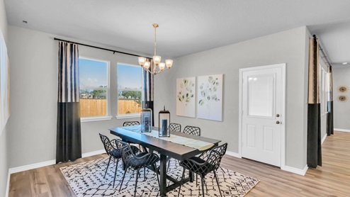 Village at Nolan Heights model home dining room with a view of the back door and backyard.