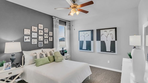 Village at Nolan Heights model home secondary bedroom with a full-size bed and carpet flooring.