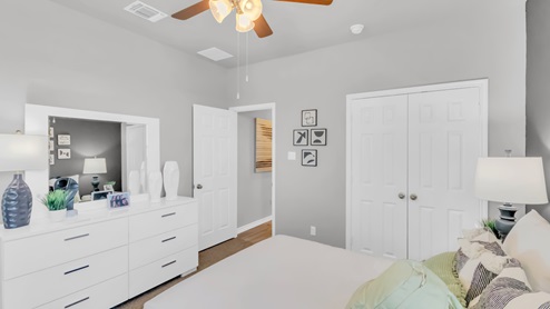 Village at Nolan Heights model home secondary bedroom with a full-size bed and view of double closet doors.