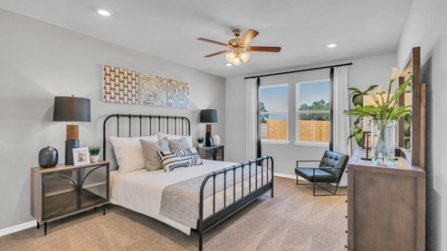 Village at Nolan Heights model home primary bedroom with a king bed and accent decor.