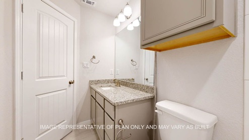 Elmwood secondary bathroom with single vanity and granite countertops.