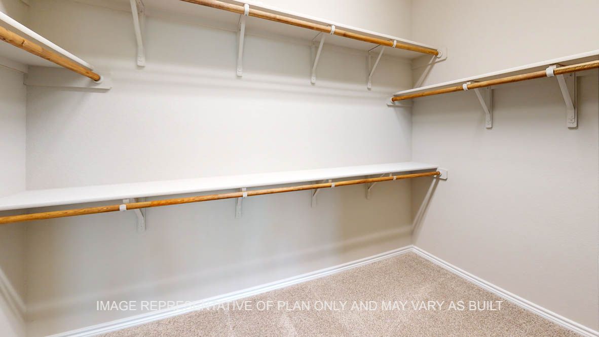 Sierra primary bedroom walk-in closet with carpet flooring and shelving.