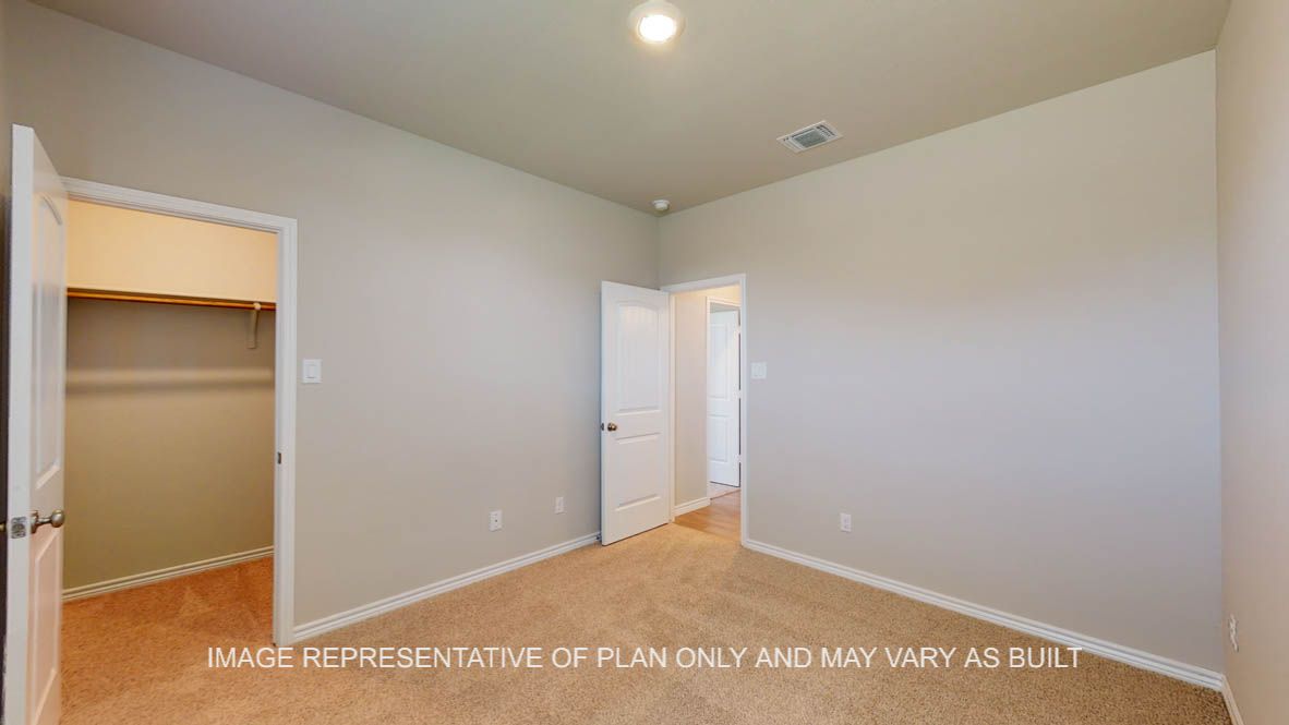 Sierra secondary bedroom with carpet flooring and walk-in closet.