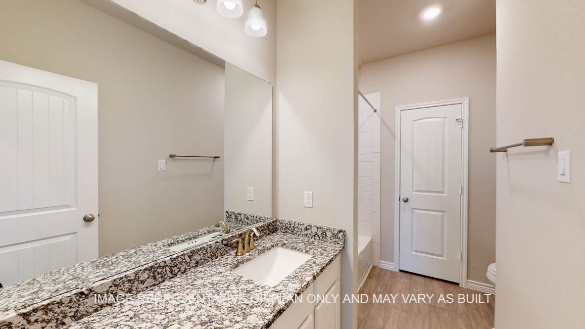 Sierra secondary bath with granite countertops and white cabinets.