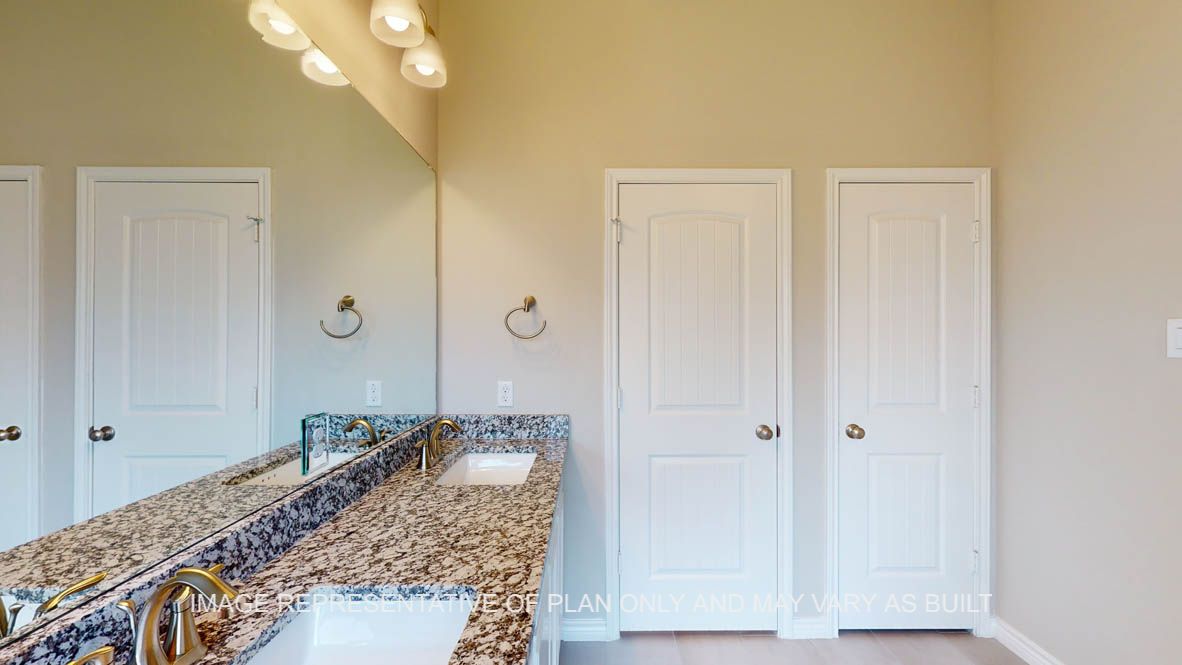 Sierra primary bath with dual vanities and granite countertops.