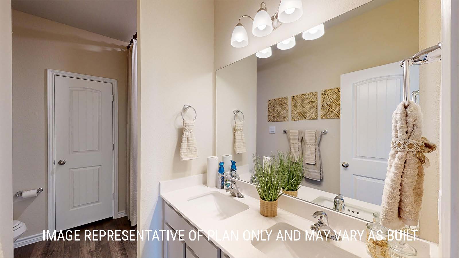 Newburgh primary bathroom with double vanity sink and light cabinets and granite countertops.