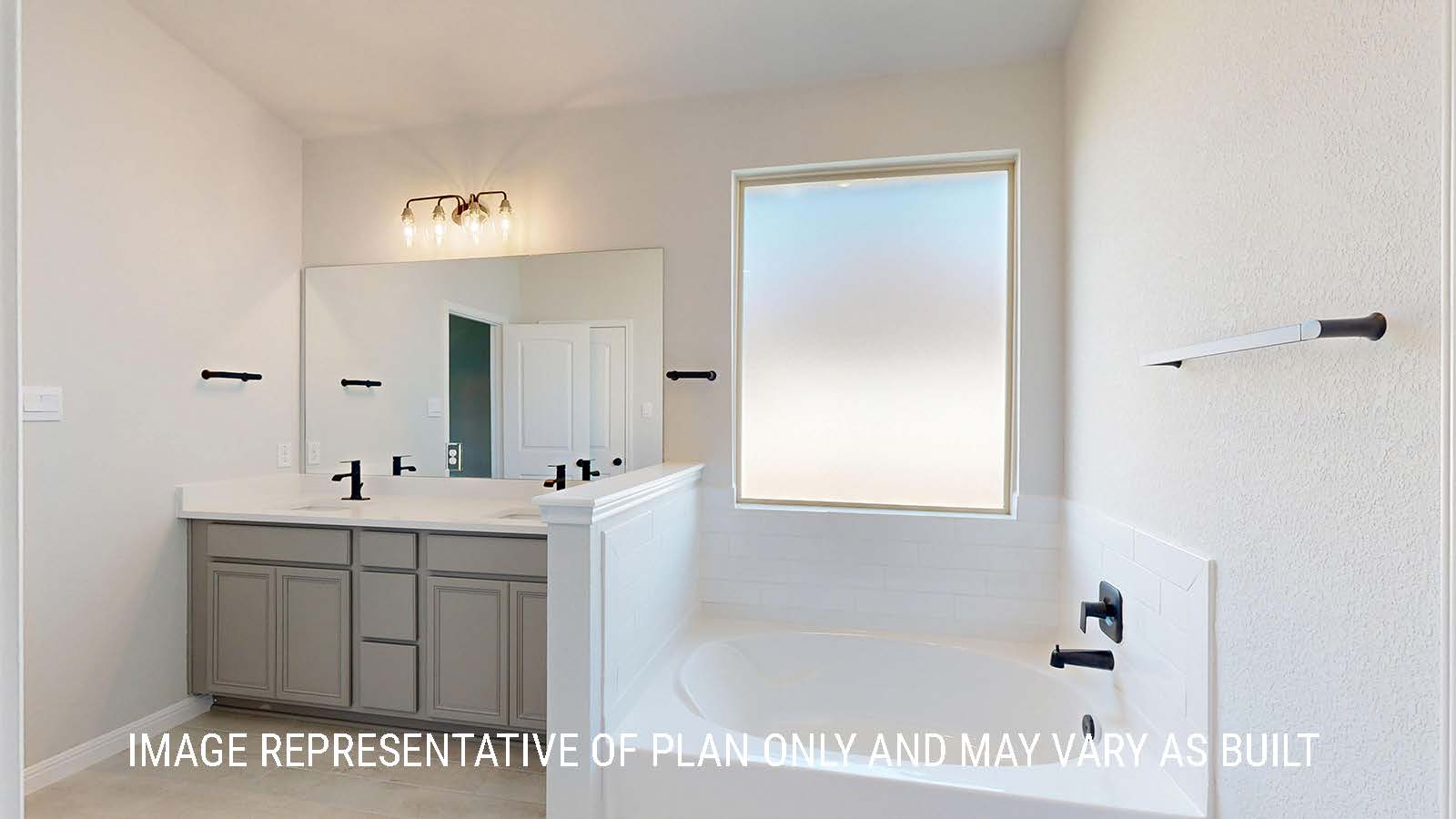 Waverley primary bathroom with duel vanity sink and garden tub with window for lighting.