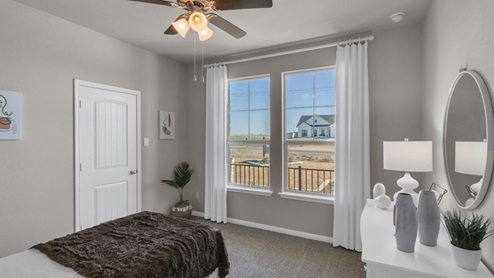 Sterling Meadows model home secondary bedroom with a twin bed and carpet flooring.