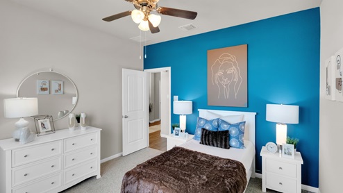 Sterling Meadows model home secondary bedroom with a twin bed and carpet flooring.