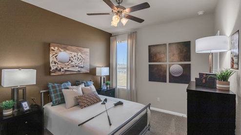 Sterling Meadows model home secondary bedroom with a full-size bed and accent decor.