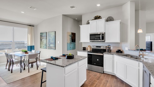 Sterling Meadows model home kitchen with white cabinets and granite countertops.