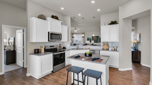 Sterling Meadows model home kitchen with white cabinets and granite countertops.