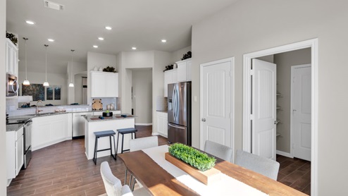Sterling Meadows model home dining room with a view of the kitchen.