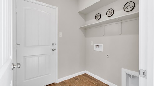 Sterling Meadows model home utility room with a storage shelving and washer and dryer connections.