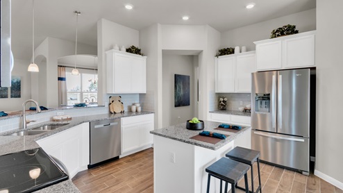 Sterling Meadows model home kitchen with white cabinets and granite countertops.