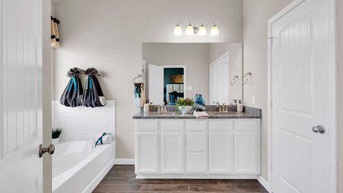 Sterling Meadows model home primary bathroom with double vanity sinks and soaking bathtub.