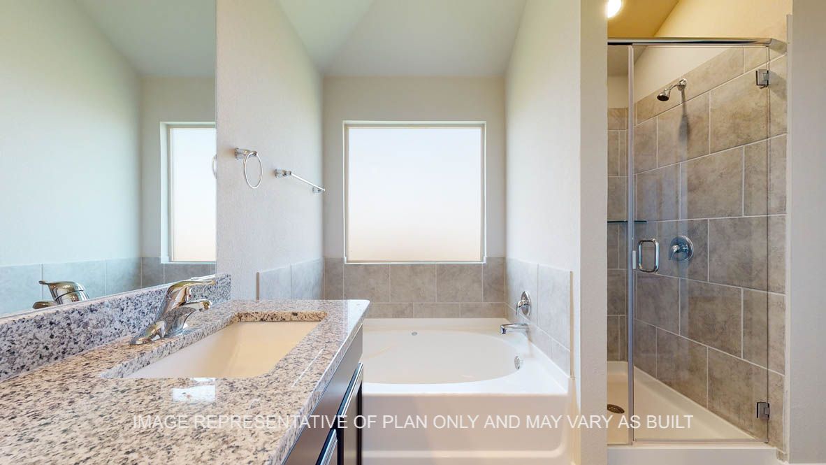 Elmwood primary bathroom with separate tub and shower and ceramic tile surround.