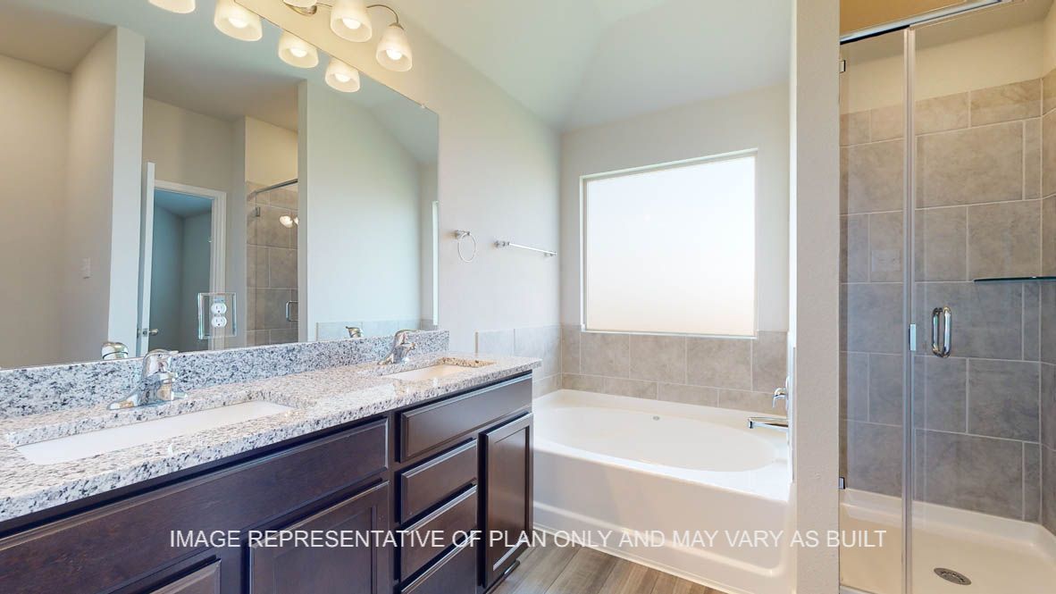 Elmwood primary bathroom with granite countertops and dark cabinets.