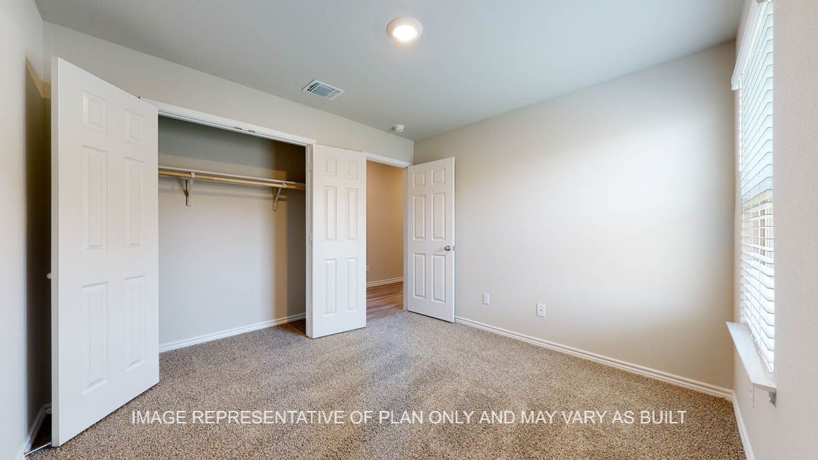 Elmwood secondary bedroom with carpet flooring and closet.